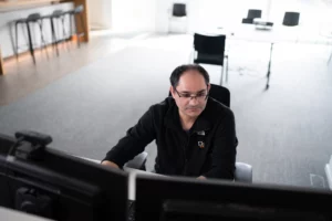 Ein Mitarbeiter der DT Netsolution kümmert sich an einem PC um das Data Management.