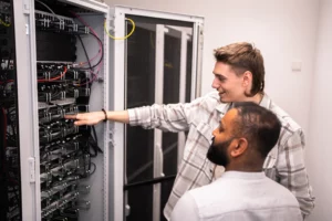 Zwei Mitarbeiter stehen vor dem Rechenzentrum der DT Netsolution.