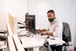 Ein Mitarbeiter von DT Netsolution arbeitet an einem PC und kümmert sich um den IT-Service.