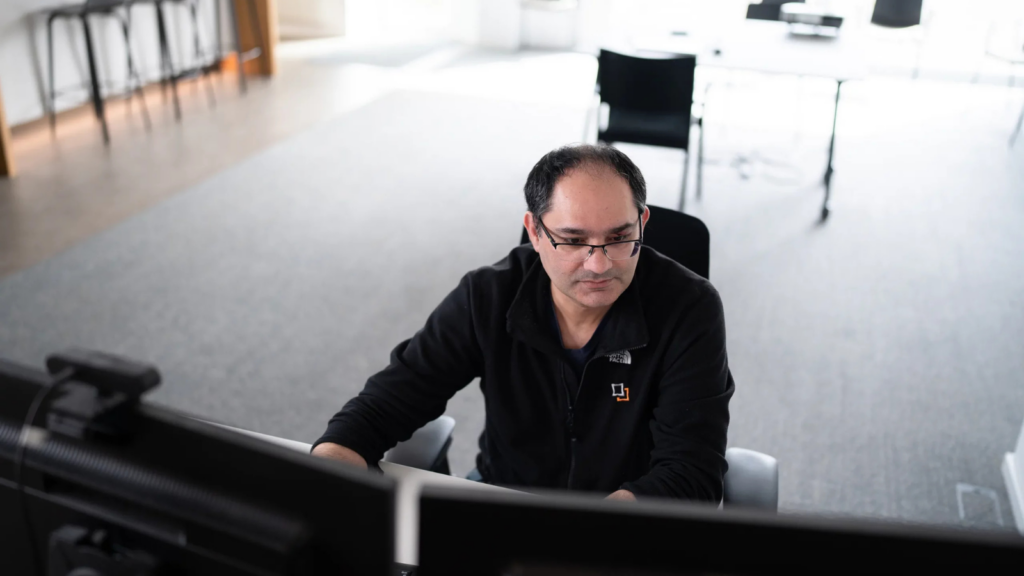 Ein Mitarbeiter der DT Netsolution kümmert sich an einem PC um das Data Management.